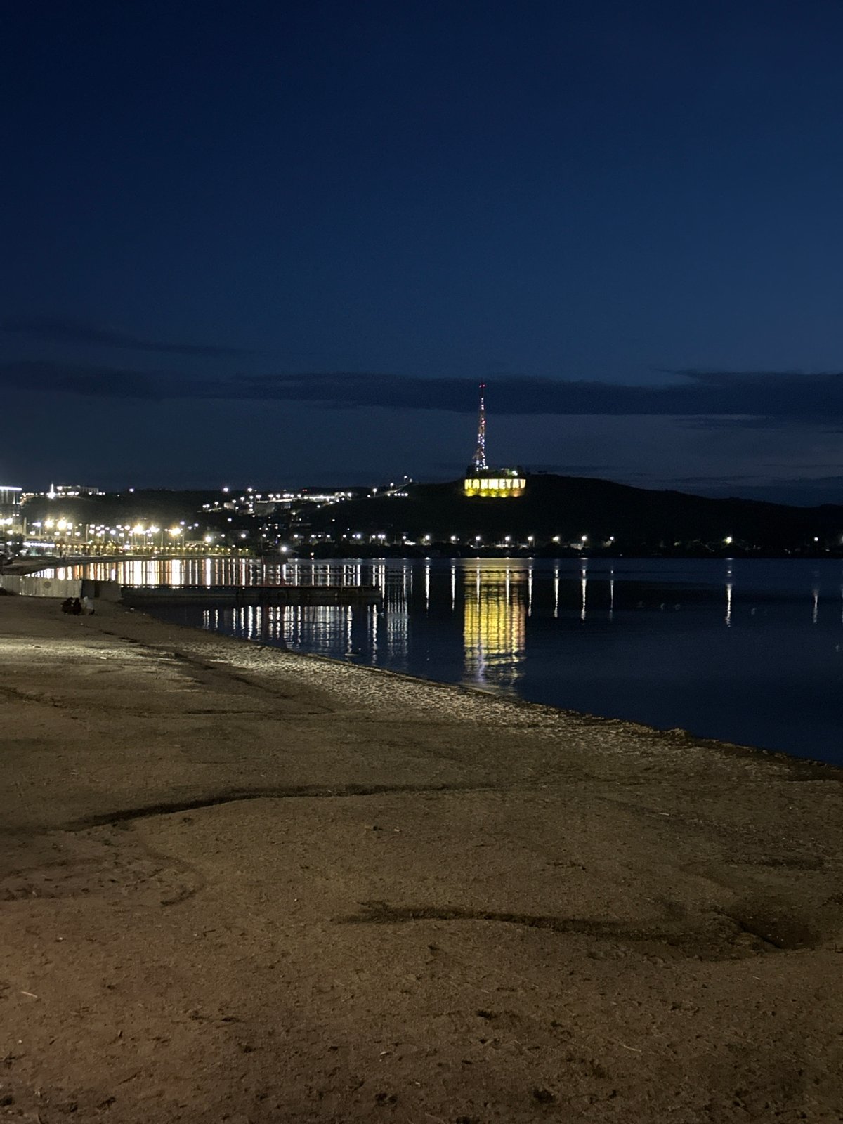 Twilight settles over Kokshetau Bay, sailboat on calm water