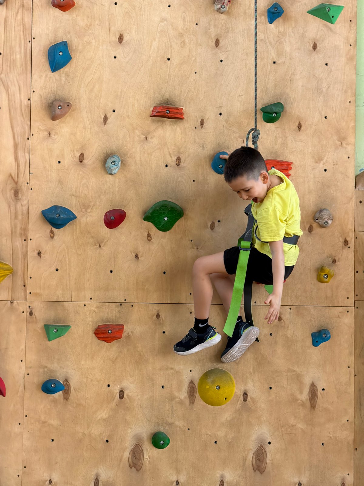 Child practices indoor rock climbing in Izhevsk facility