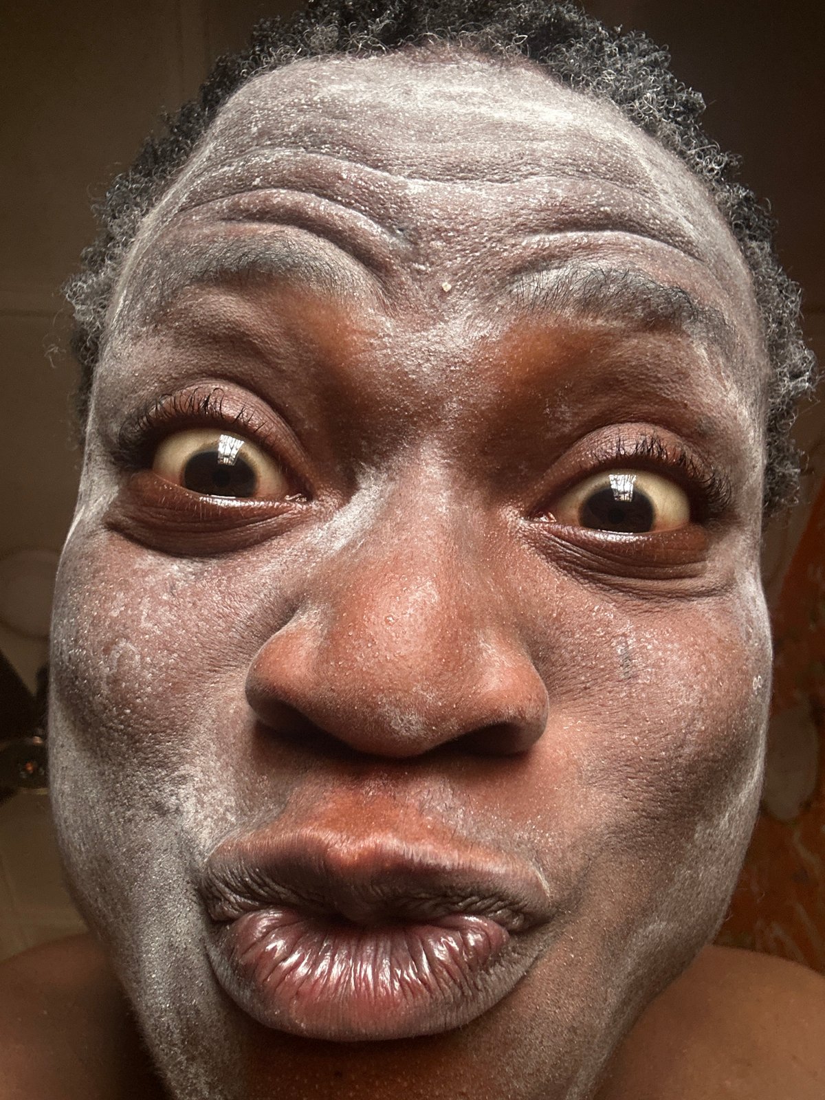 Person documents skincare routine with powder and lotion application