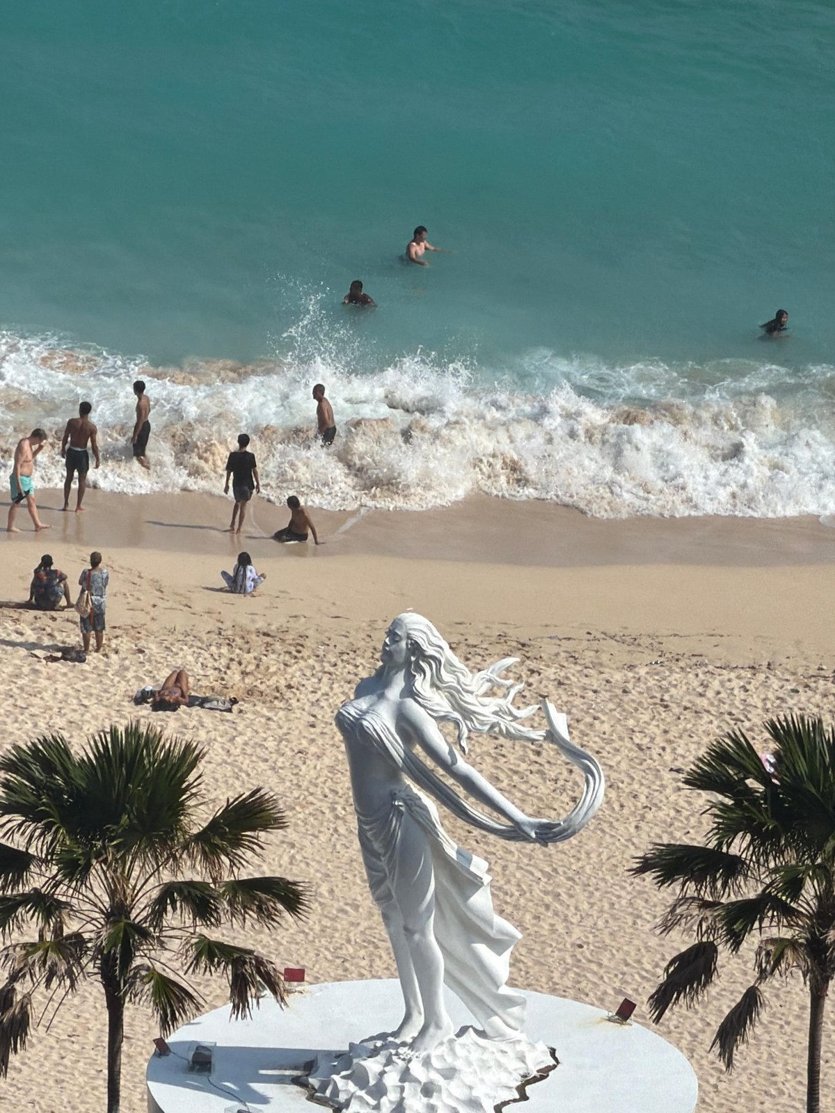 Tourists capture scenic Bali coastal views and statues