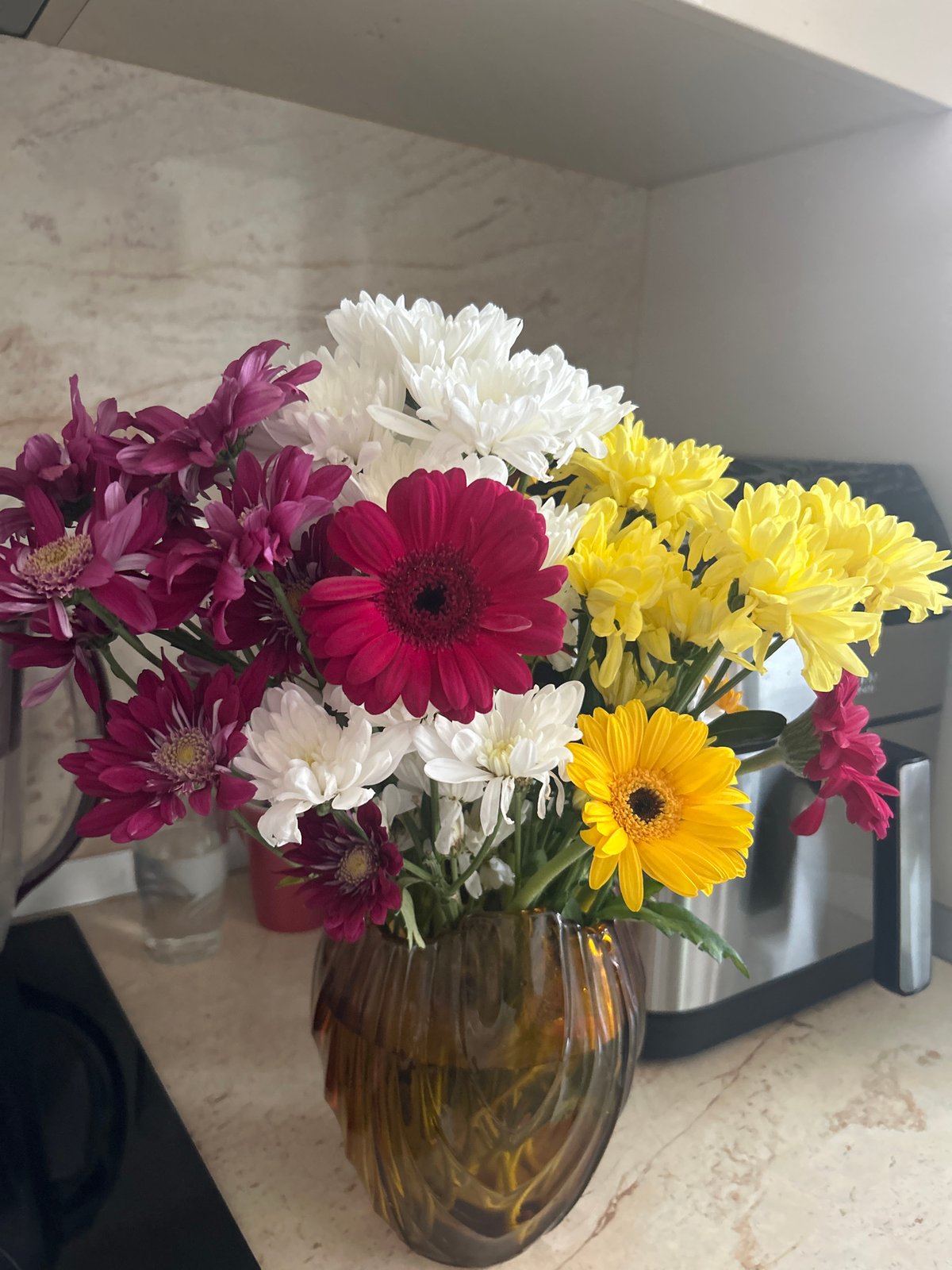Mixed flower bouquet displayed in amber vase