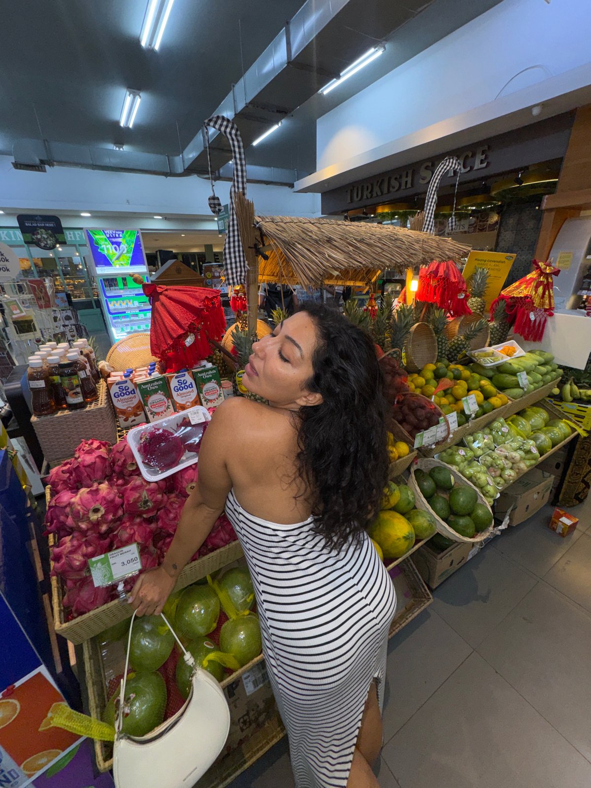 Woman shops tropical fruit section in North Kuta market