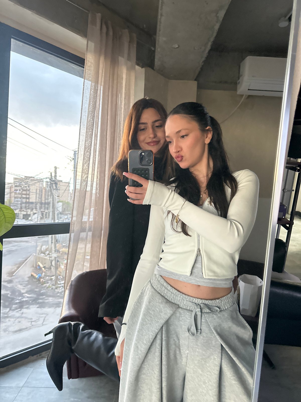Woman takes mirror selfies in modern Zovuni interior space