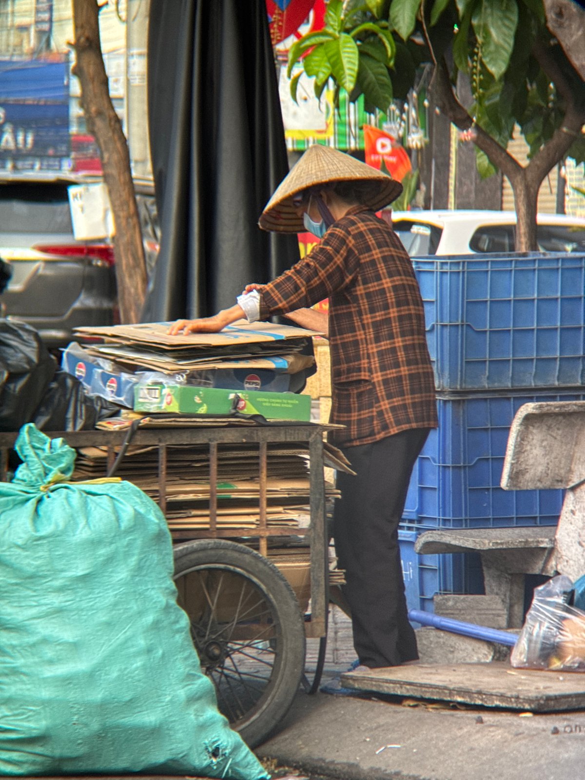 Everyday street life in Nha Trang, recycling collector and passersby