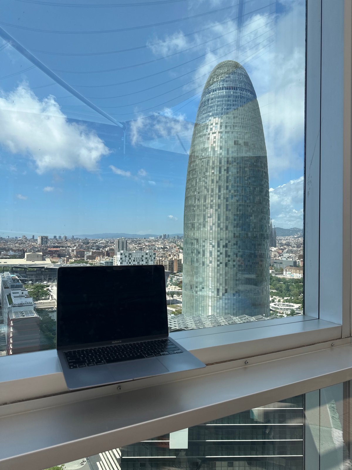 Laptop workstation captures Barcelona skyline view with Torre Glòries
