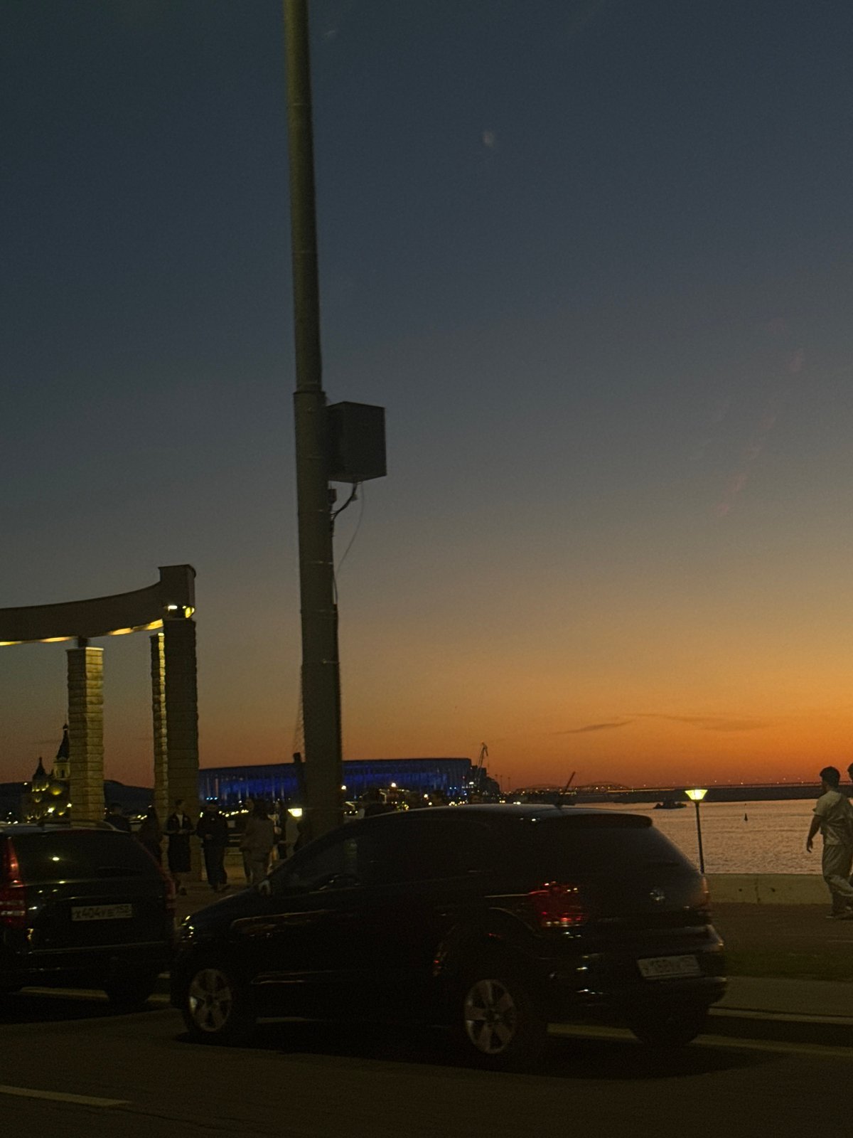 Evening crowd gathers for illuminated fountain display at waterfront