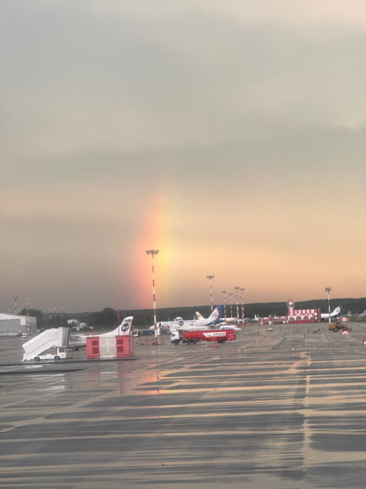 Rainbow over a wet Koltsovo Airport tarmac after summer rain