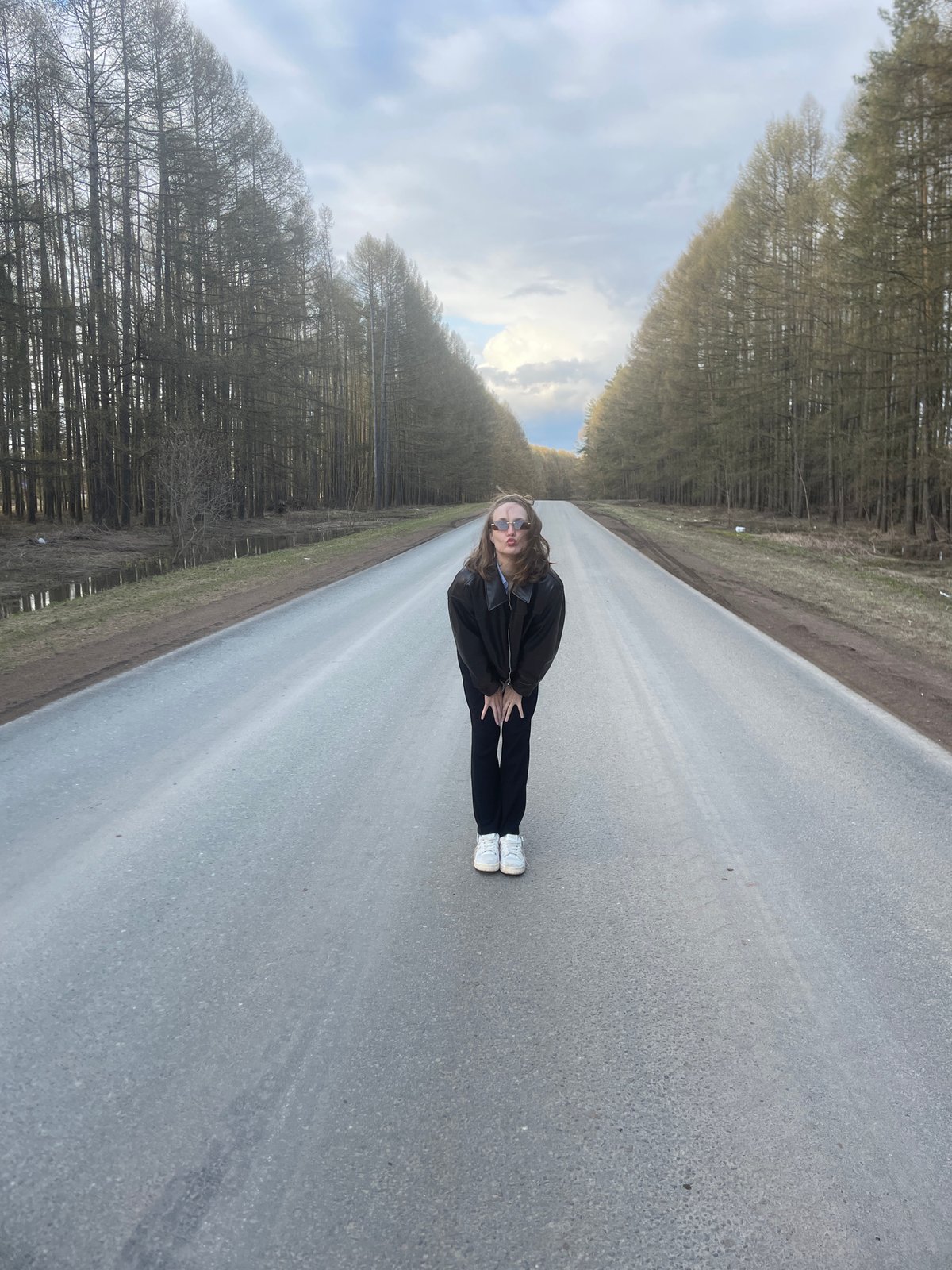 Two people photographed on tree-lined road in Podshivalovo, Russia