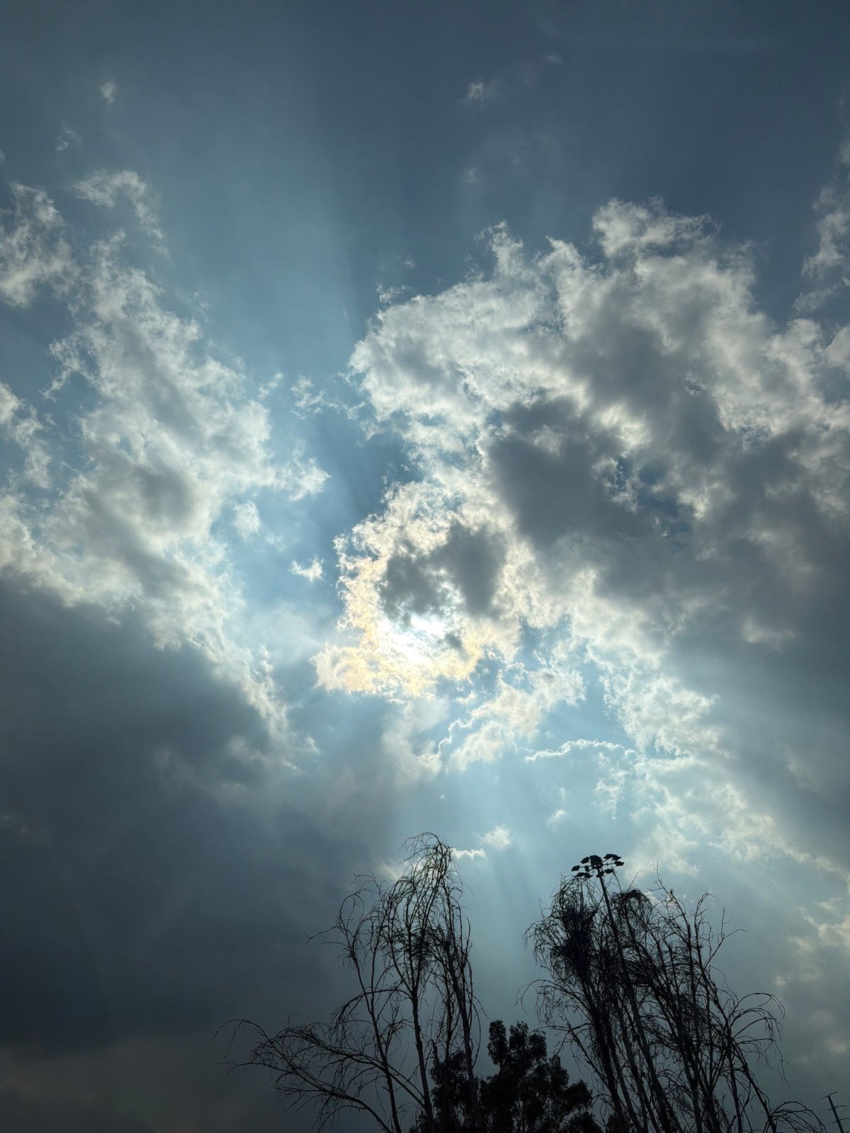 Witness captures sun rays breaking through clouds creating halo effect