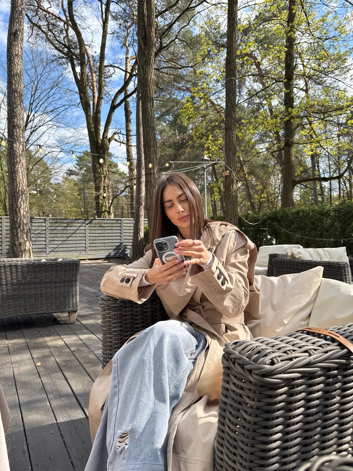 Woman uses smartphone at outdoor cafe in Konstancin-Jeziorna