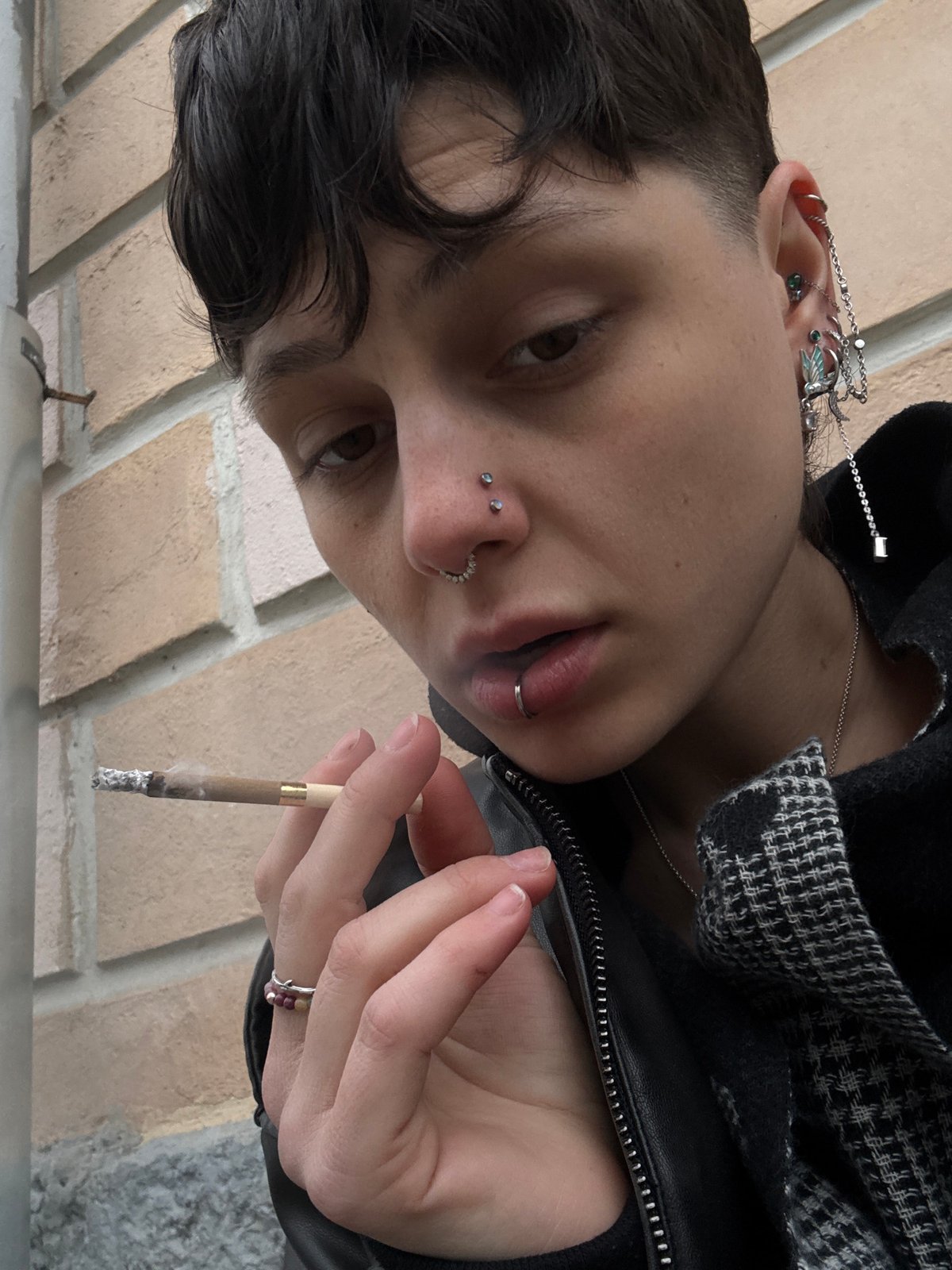 Person with facial piercings photographed smoking in Moscow