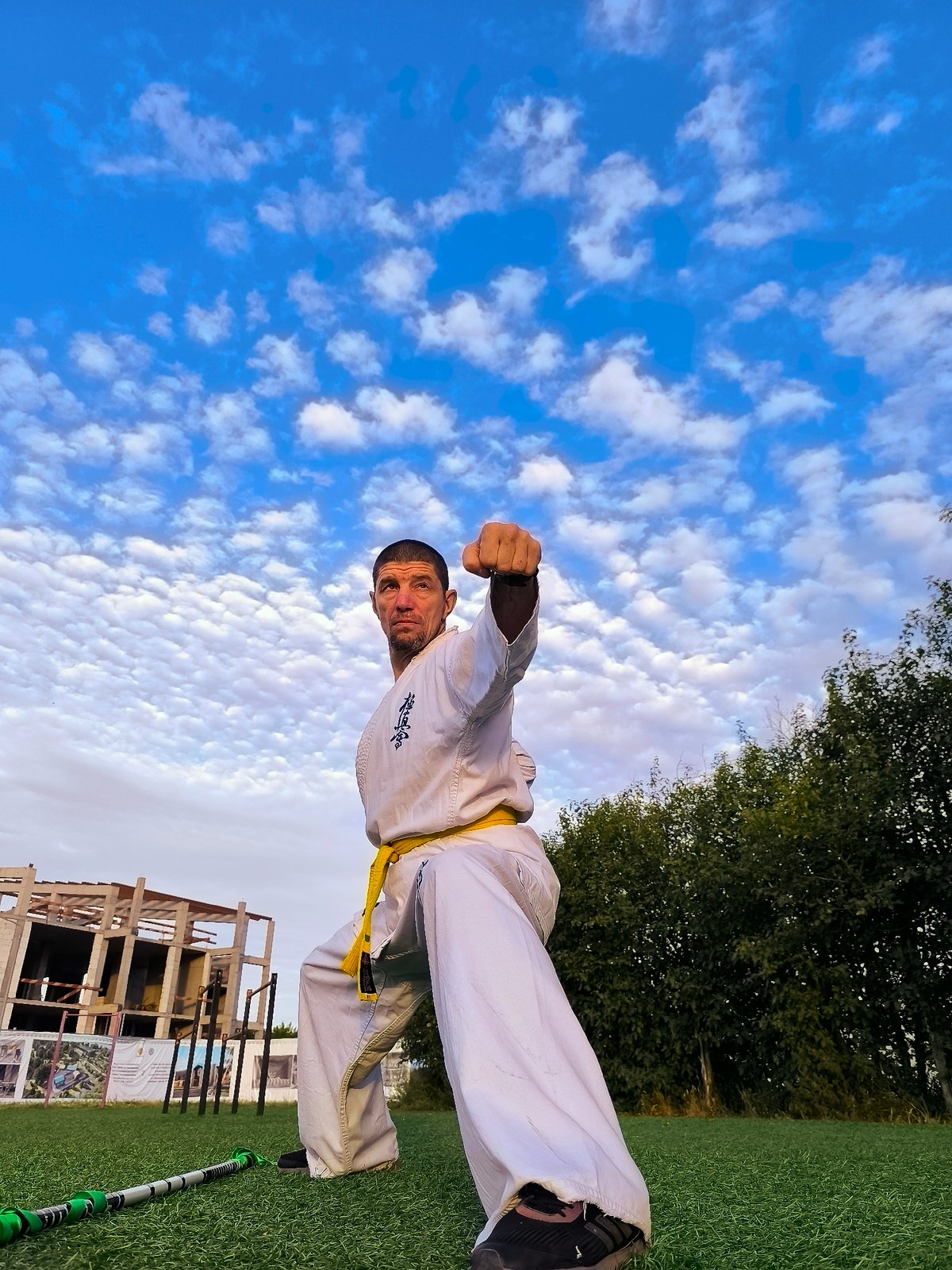 Yellow-belt karate practice on turf in Qarağandı