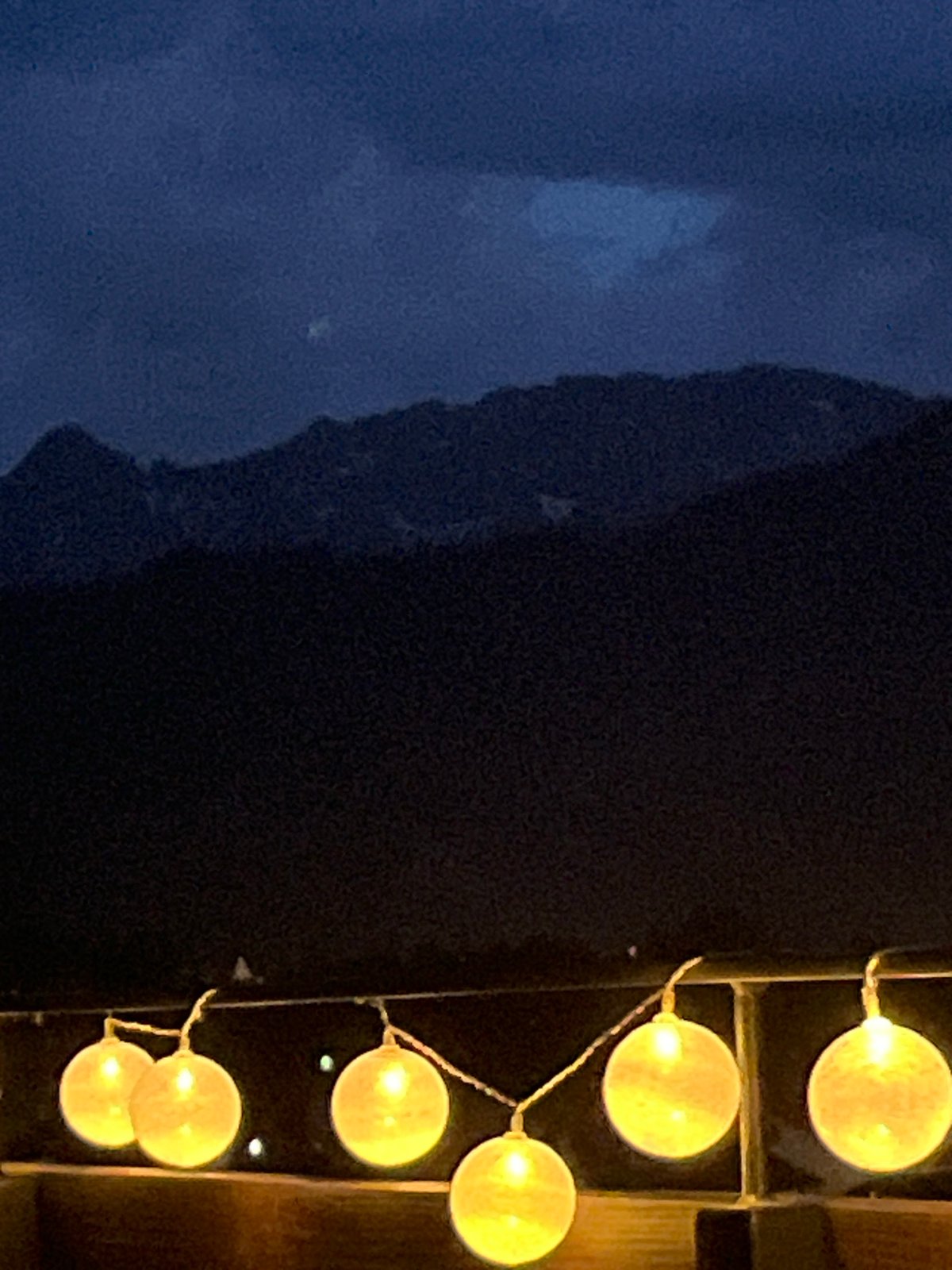 String lights and mountain silhouettes on a Garmisch evening terrace
