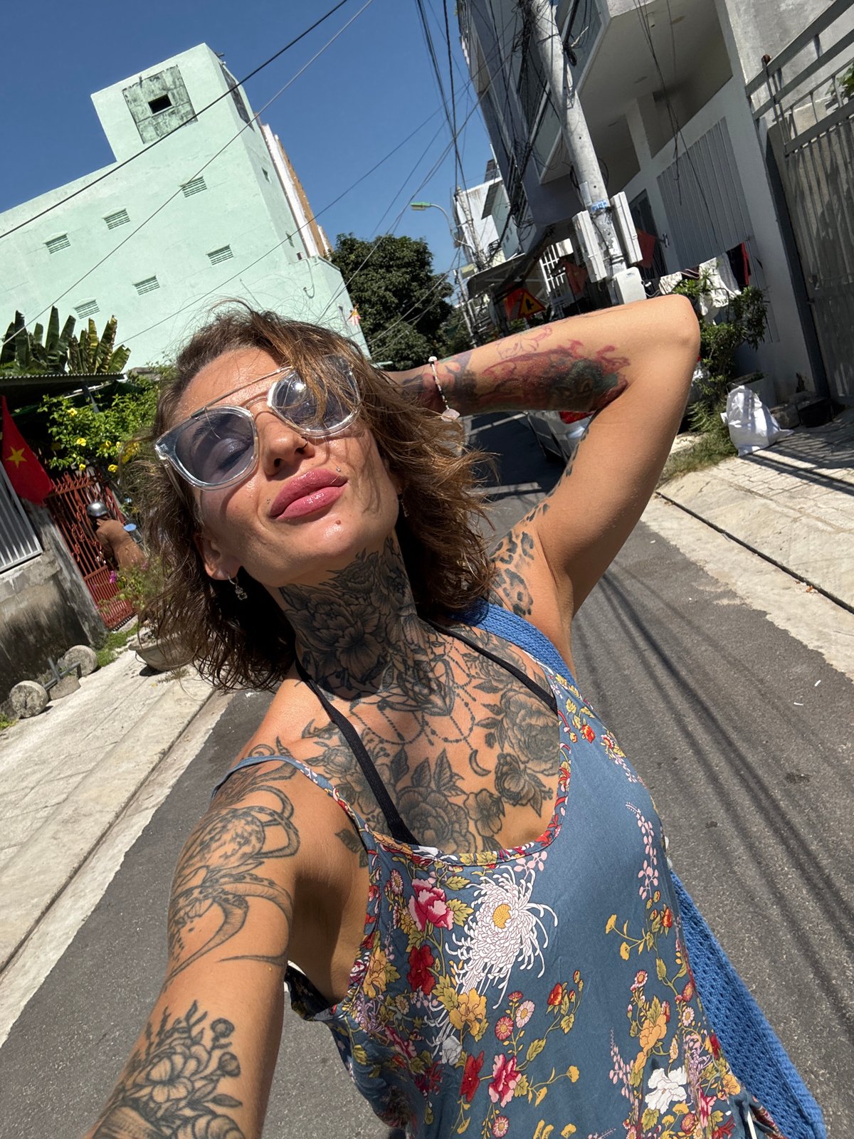 Woman records selfies near flag-decorated shops in Nha Trang