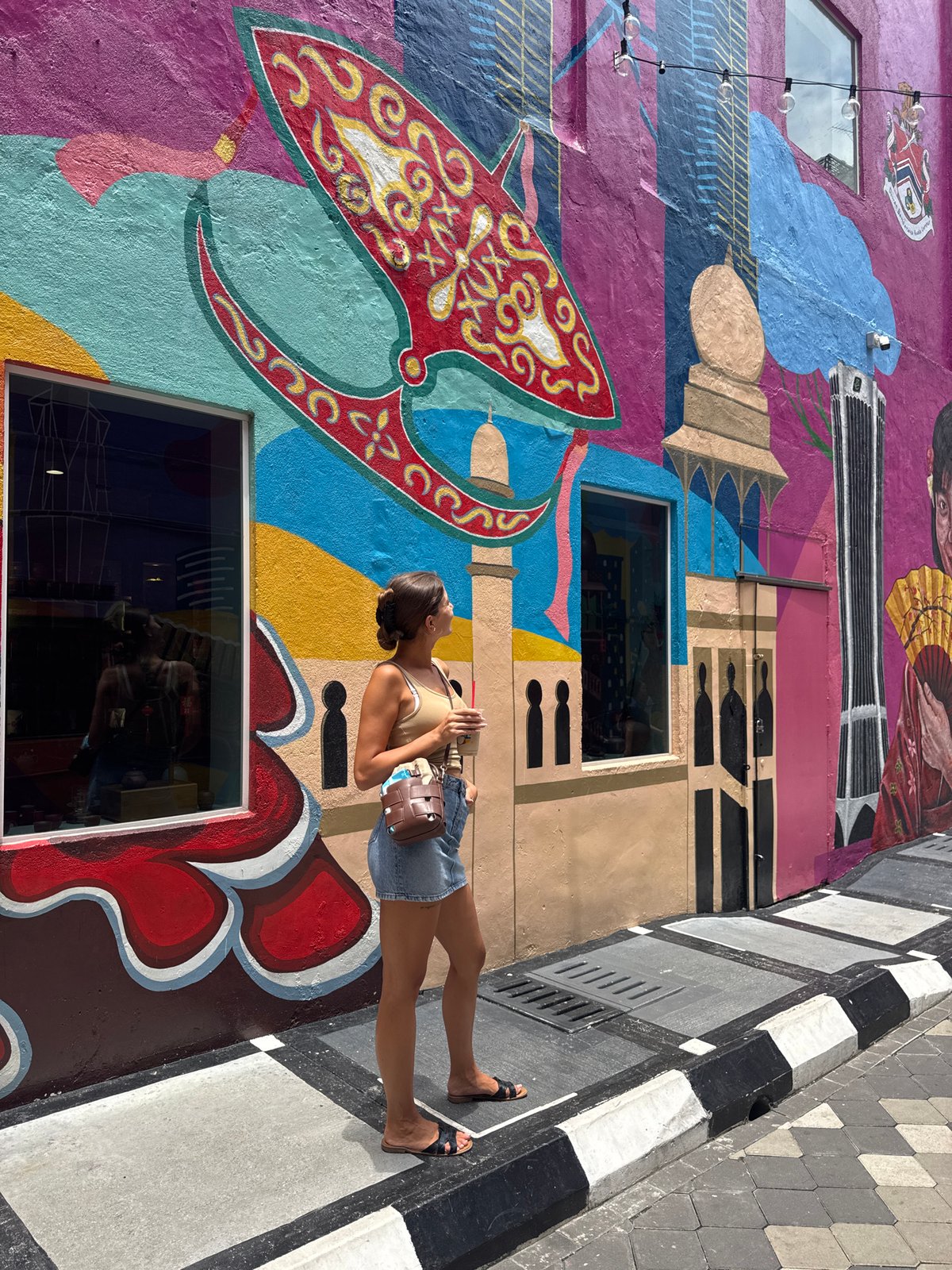 Early morning visitors photograph colorful street murals in Kuala Lumpur