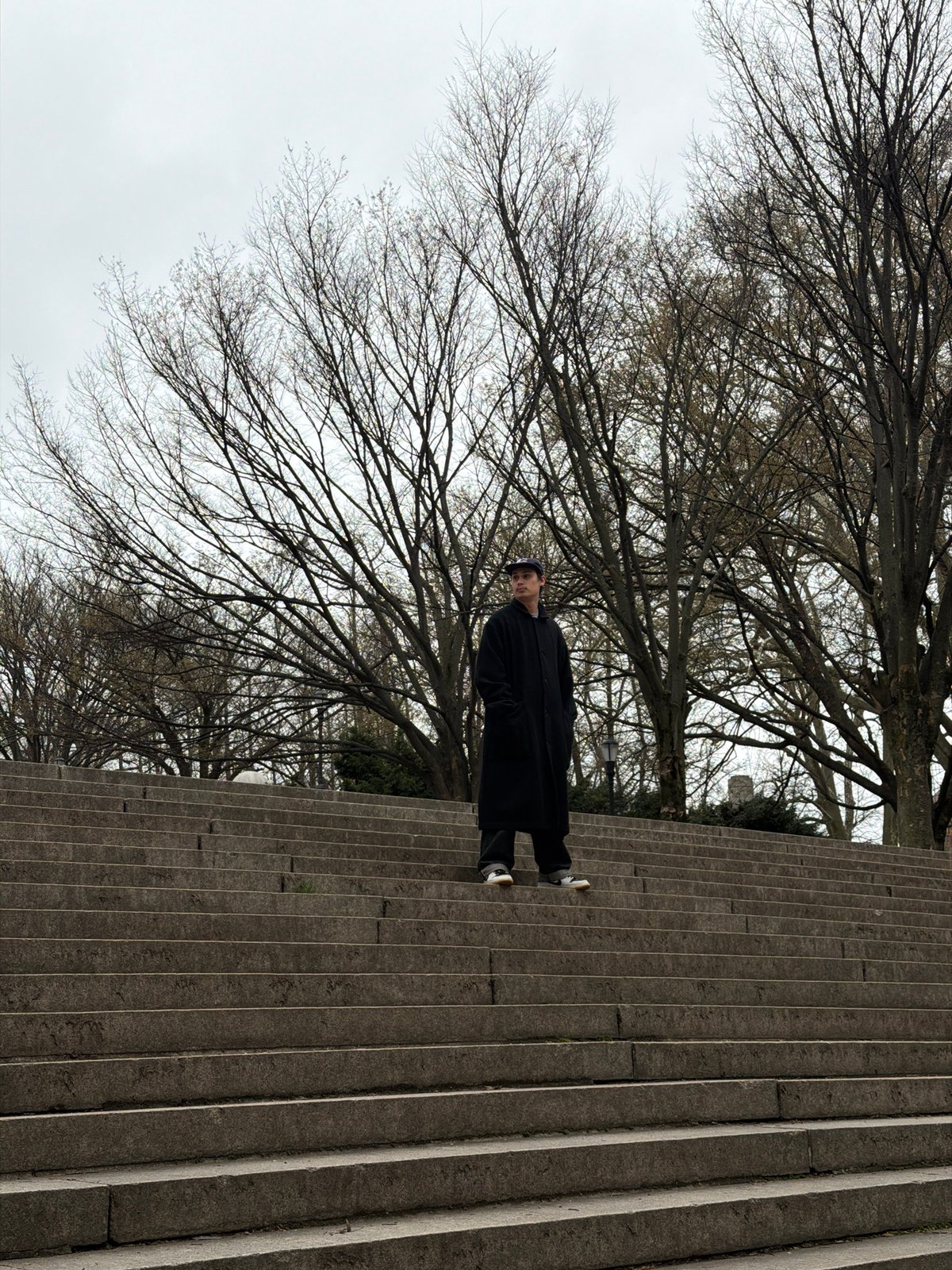 Figure in black coat spotted on NYC stairs near park