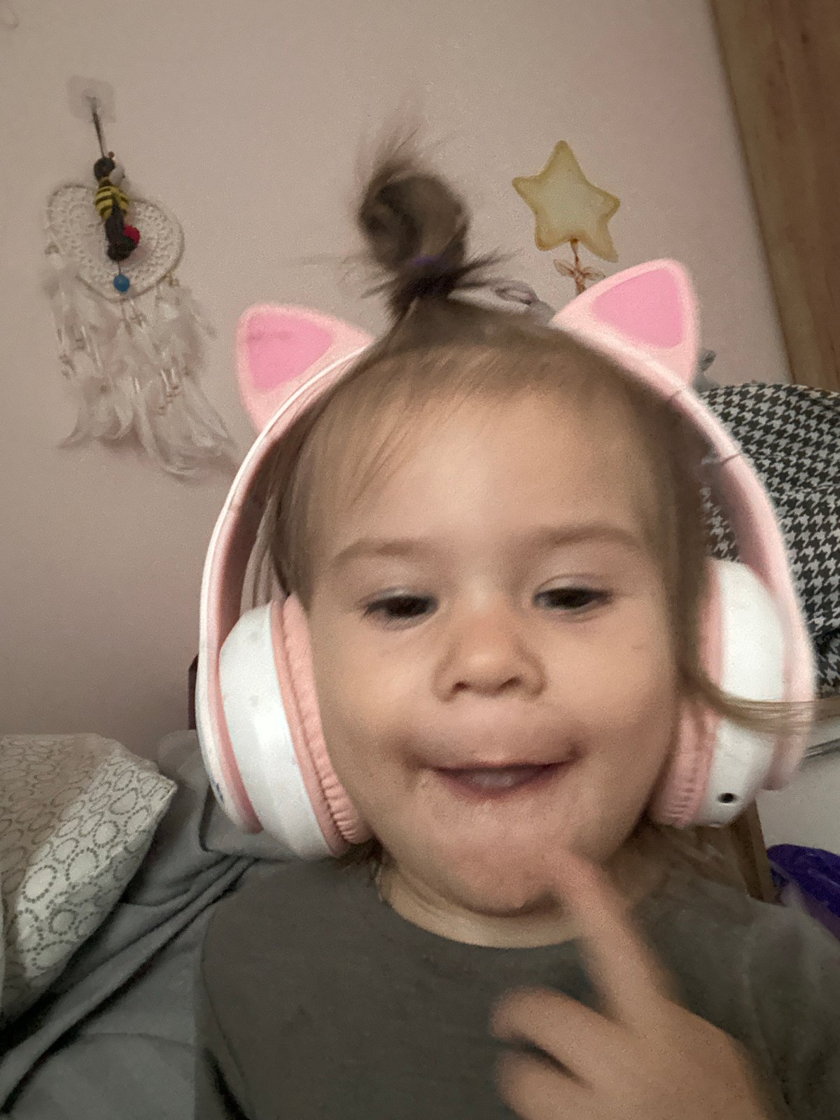 Child with cat-ear headphones spotted smiling indoors in Russia