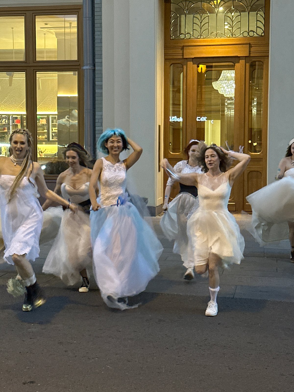 Wedding dresses and blue hair on a Moscow street at dusk