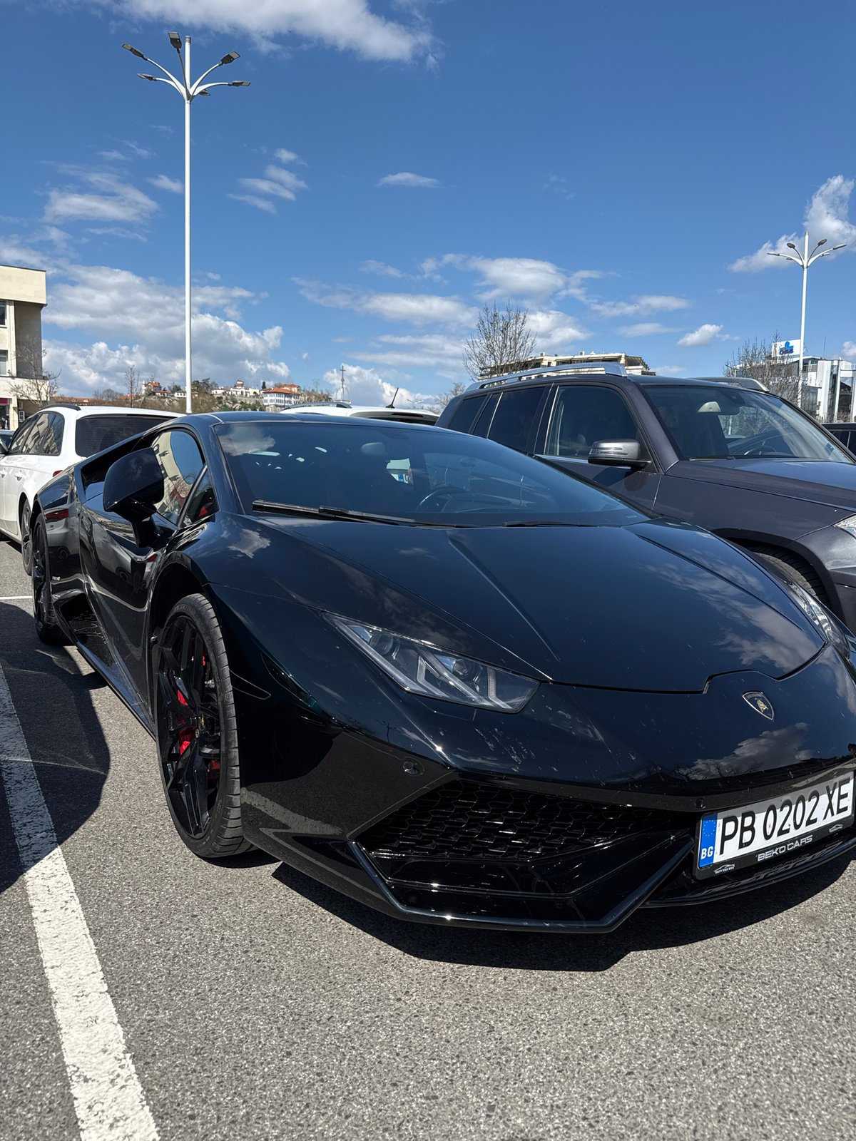Man poses with luxury cars in Plovdiv parking lot