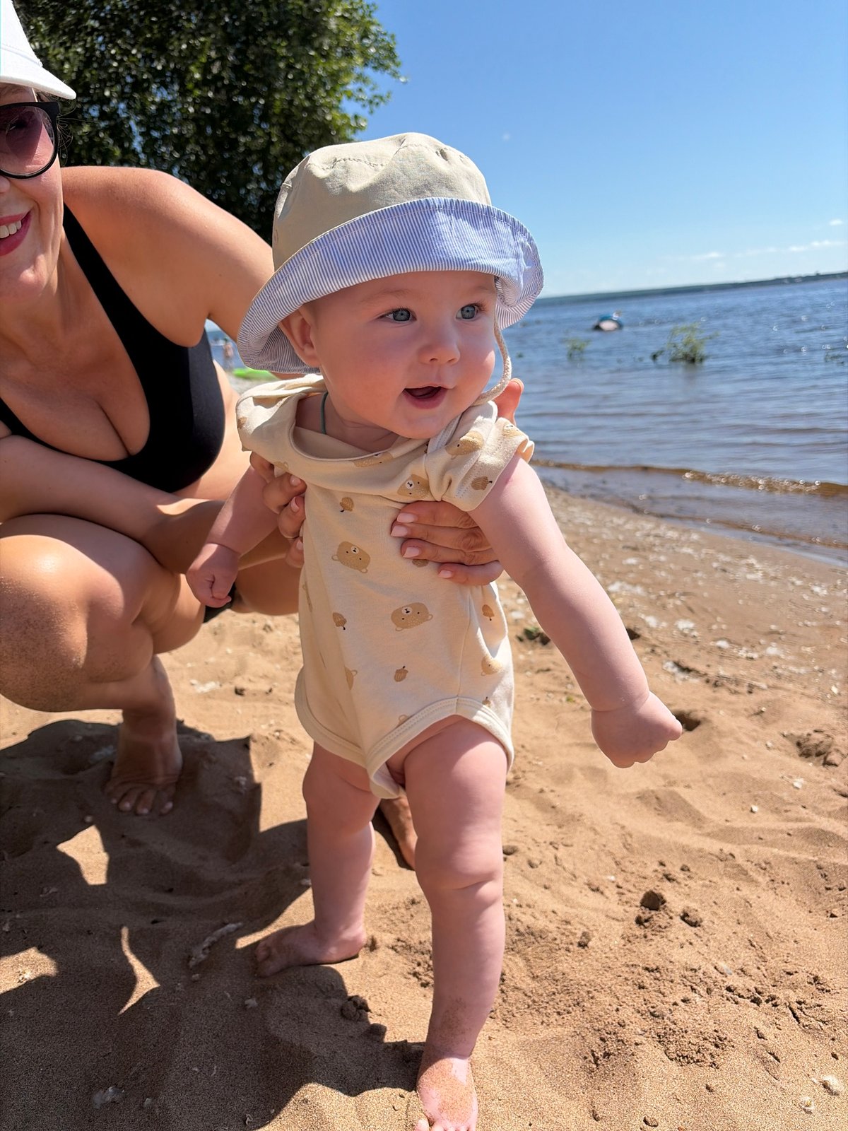 Baby's first beach day on a Russian summer shore