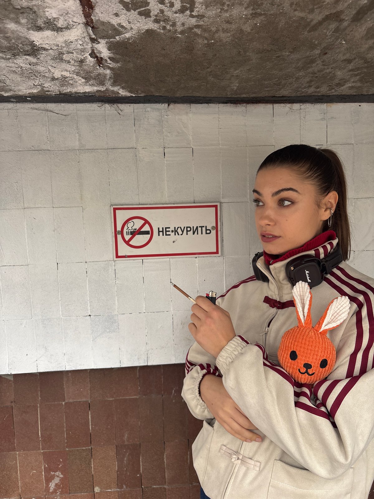 Woman smokes beside no-smoking sign in Moscow