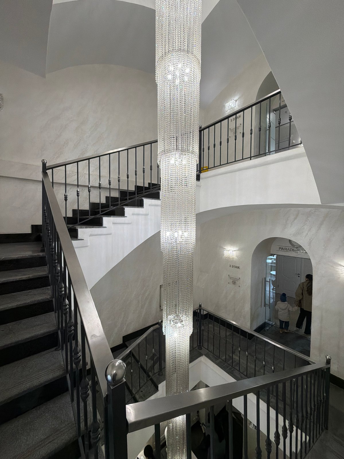 Large crystal chandelier documented in Moscow multi-story staircase interior