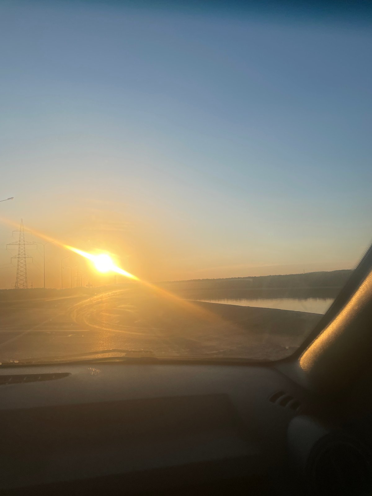 Vehicle passenger captures sunny landscape view with power lines