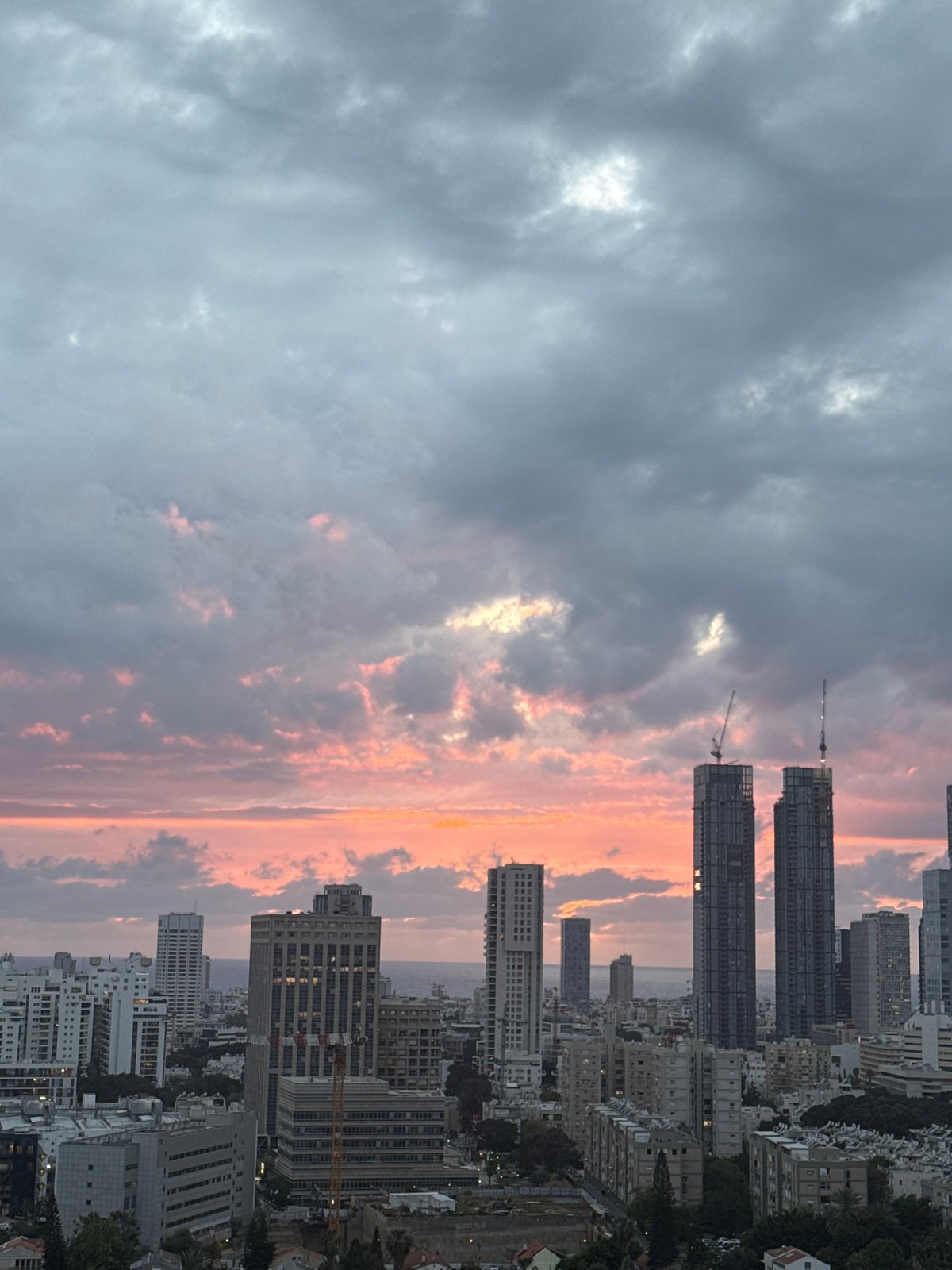 Tel Aviv skyline photographed at dusk with construction cranes