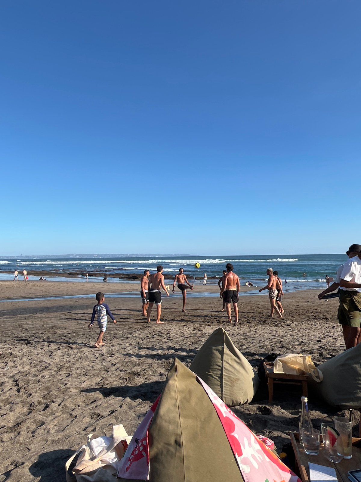 Busy beach morning in North Kuta — soccer, sun, and sand
