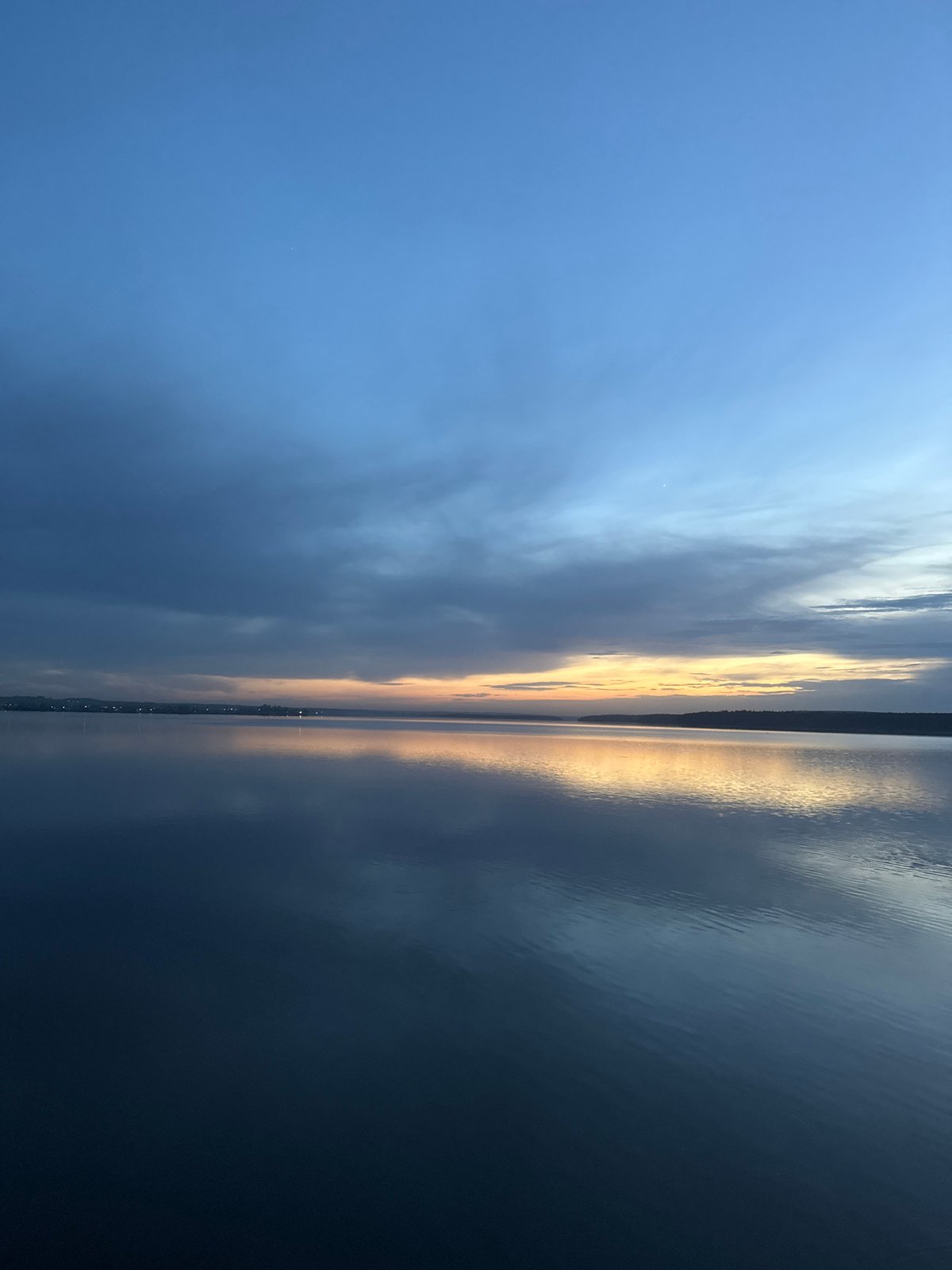 Sunset reflection captured over Votkinsk waters amid mixed clouds