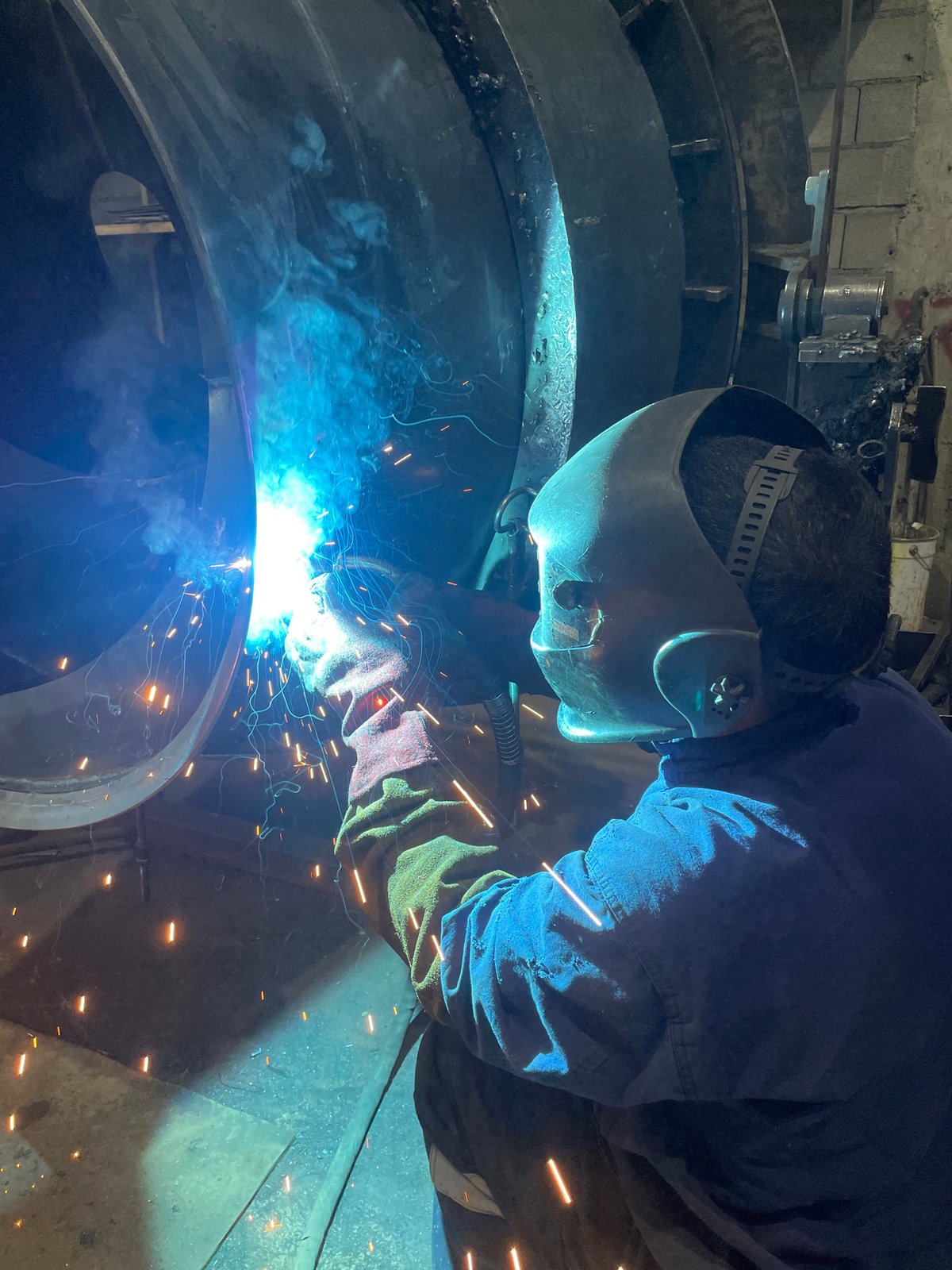 Welder works on large metal structure in Montenegro factory