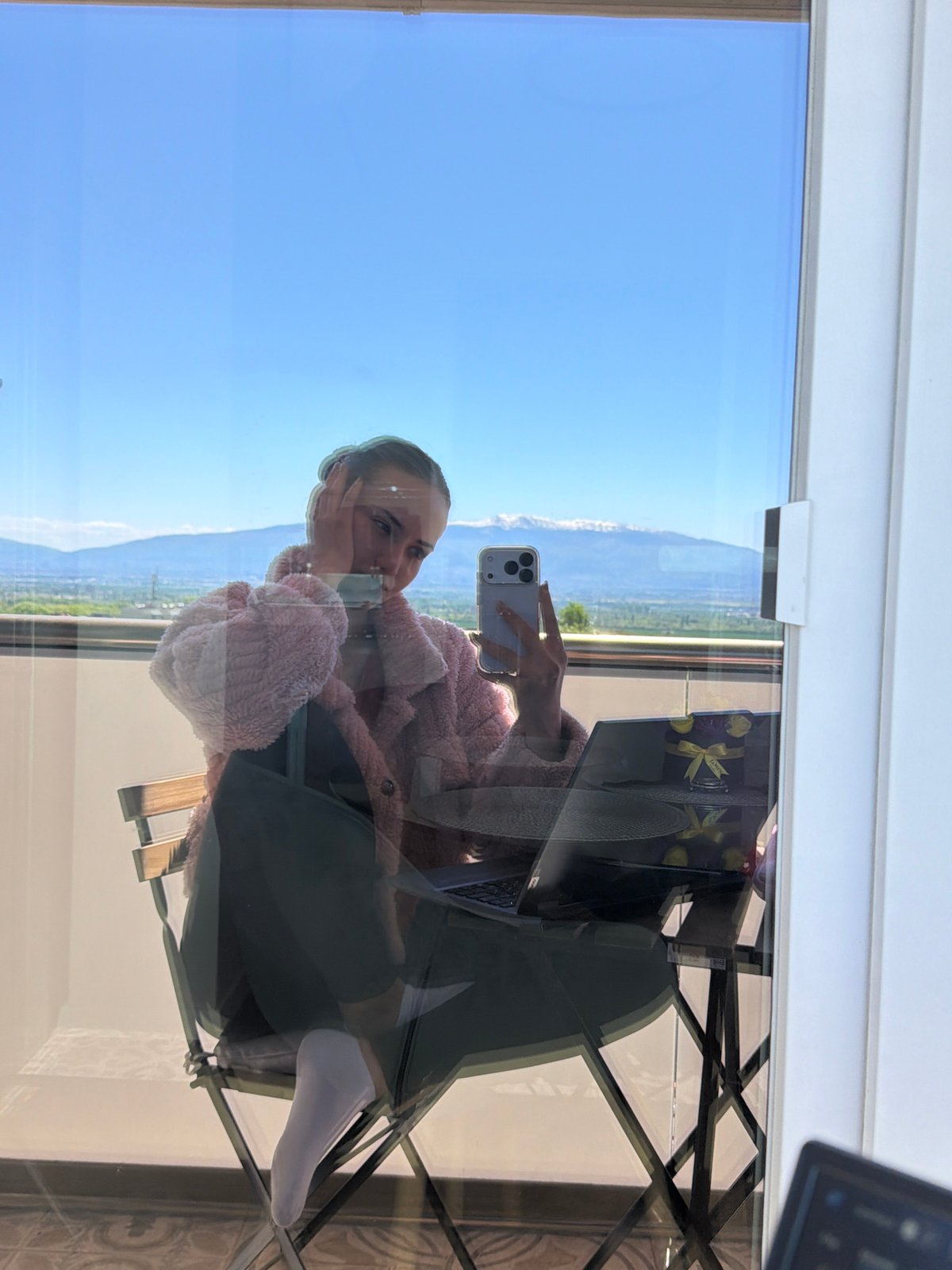 Woman takes selfies on balcony in Buhovo, Bulgaria