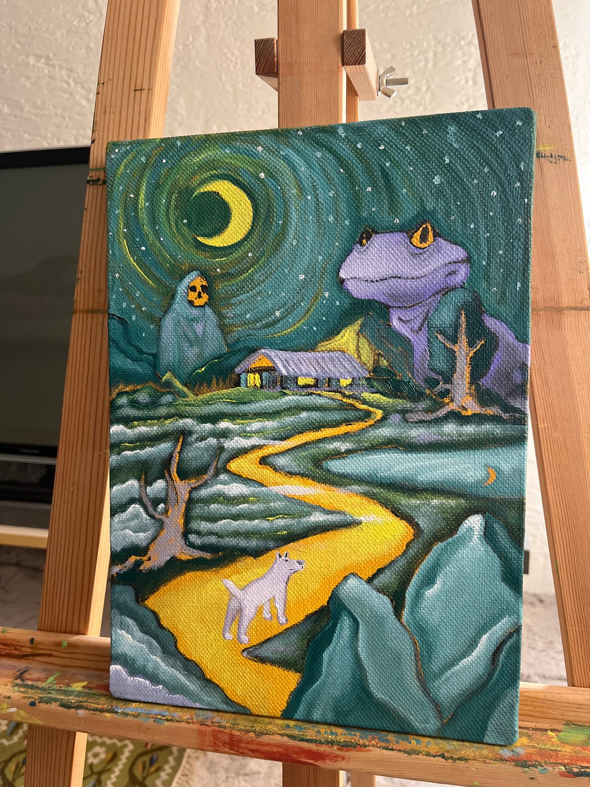 Abstract landscape painting displayed on easel features vibrant colors