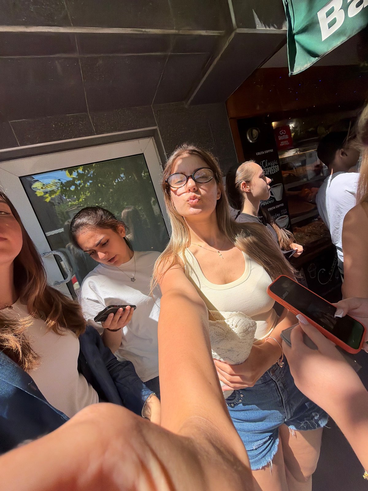 Young women take selfies outside Burgas shops morning
