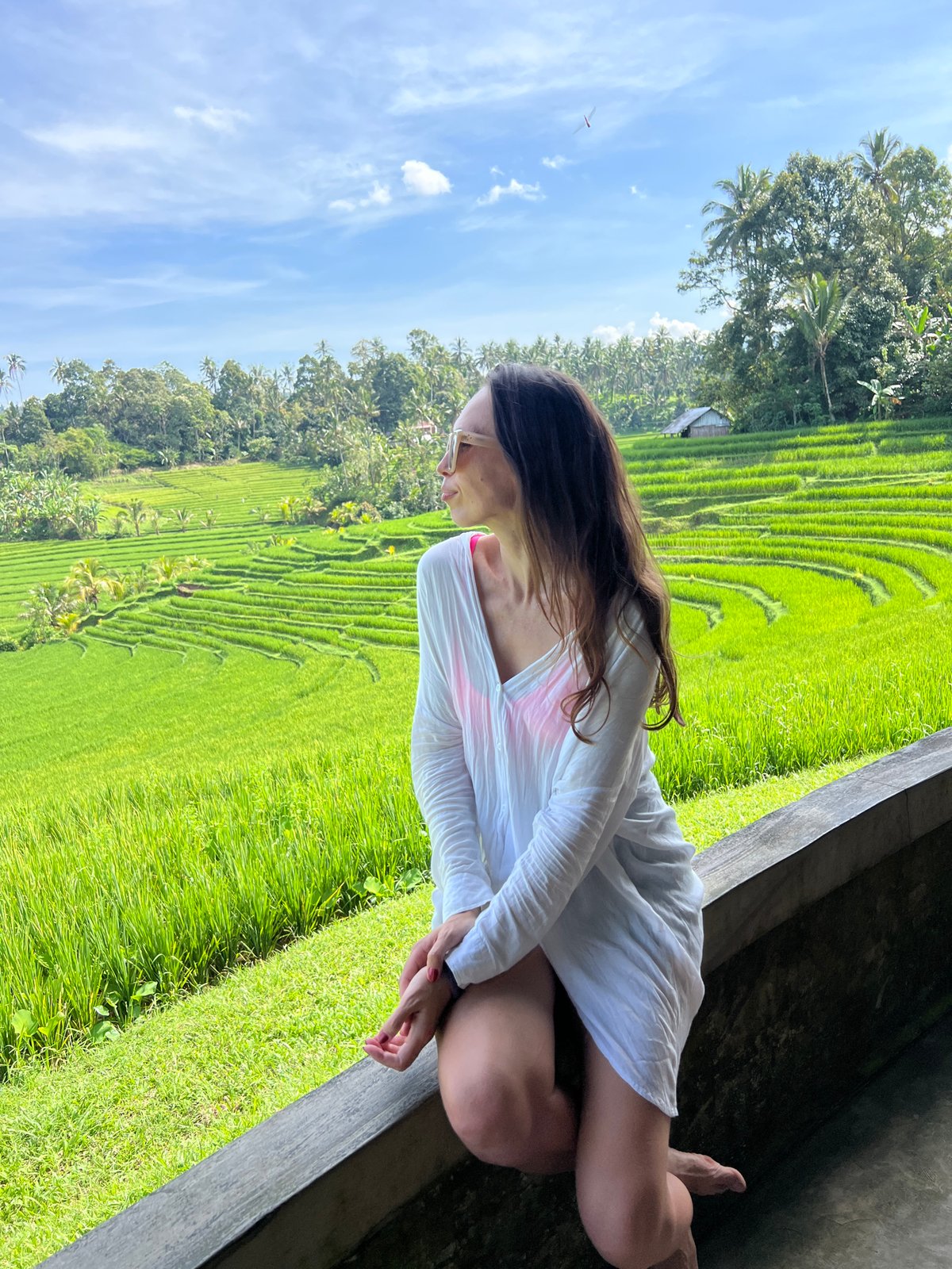 Woman photographs scenic rice terraces in Pupuan, Indonesia