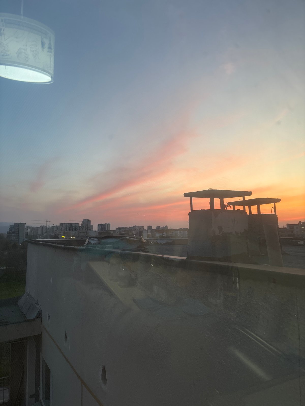Sunset captured over Plovdiv cityscape from building interior