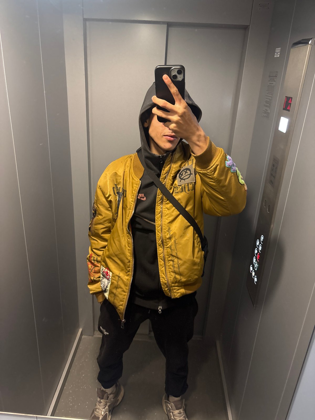 Person takes elevator selfie in yellow jacket, Shumen