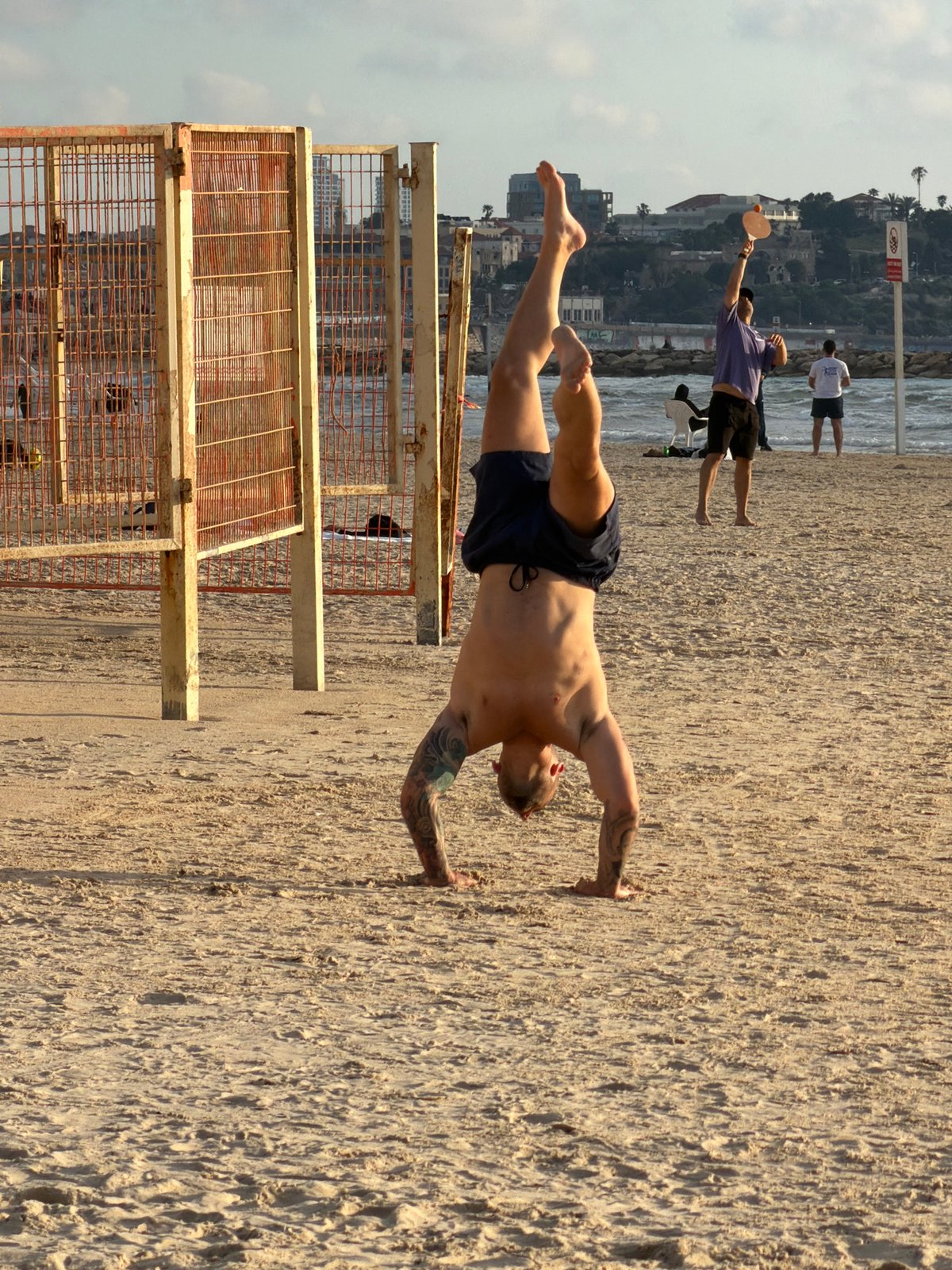 Helicopter flies over Tel Aviv beach during afternoon Matkot games