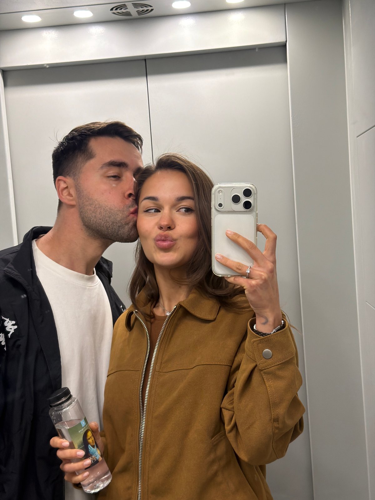 Couple Takes Playful Selfie in Indoor Mirrored Space