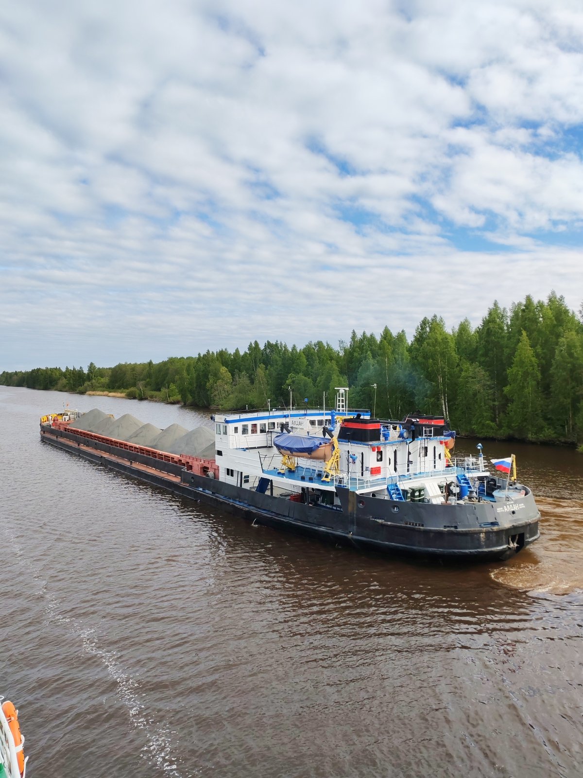 Cargo barges and boats navigate waterways in Vytegra, Russia