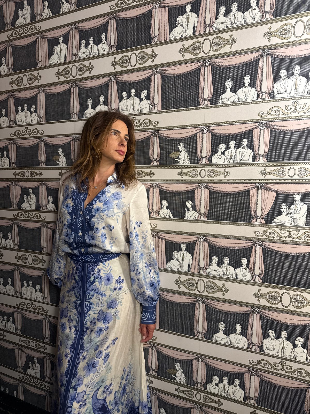 Two women take selfies in patterned room in Vila Verde