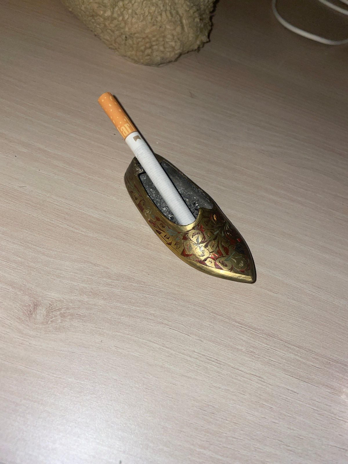 Lit cigarette observed burning in decorative ashtray in Paris