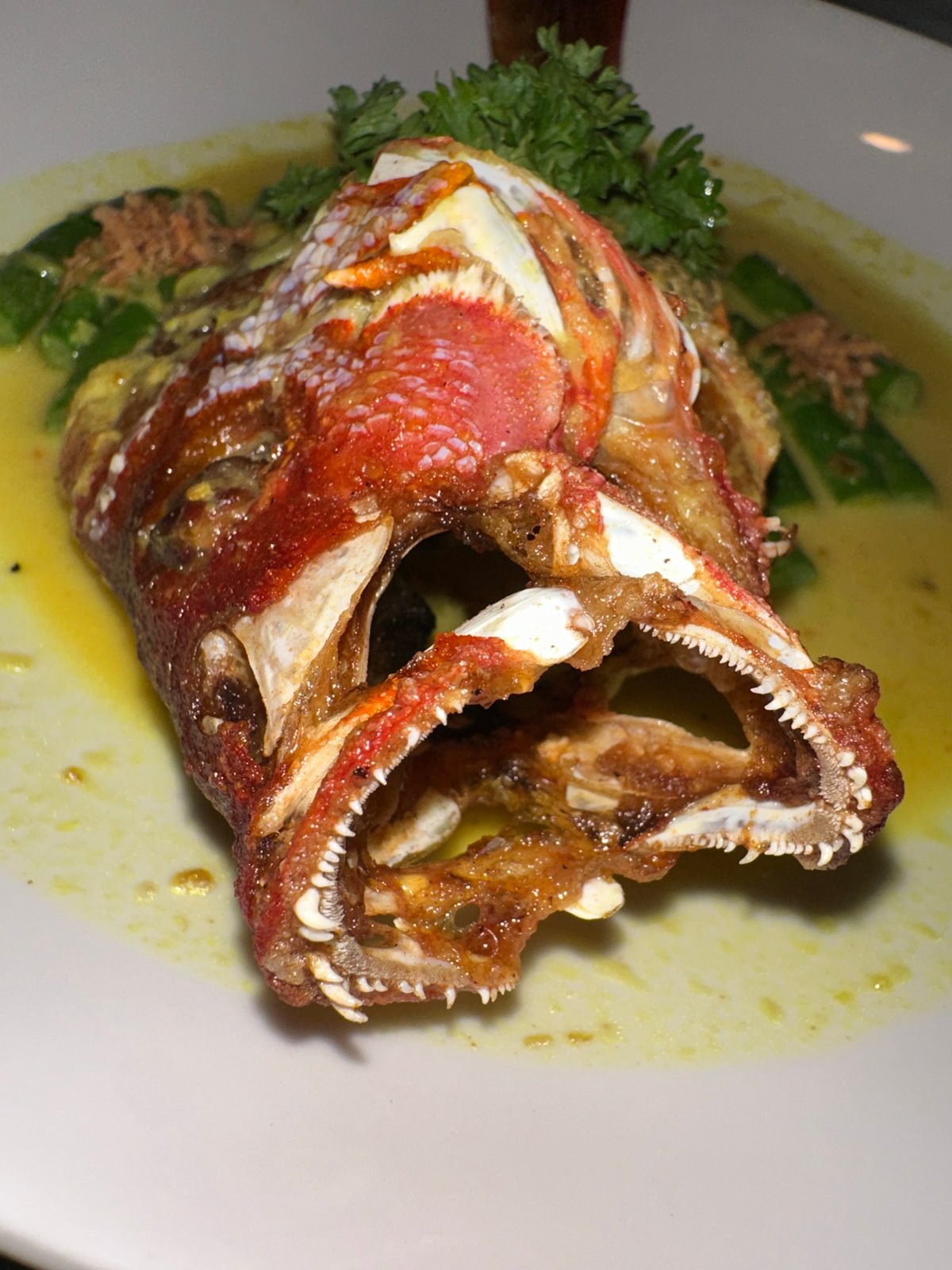 Restaurant diners document fish head meal in Nusa Penida