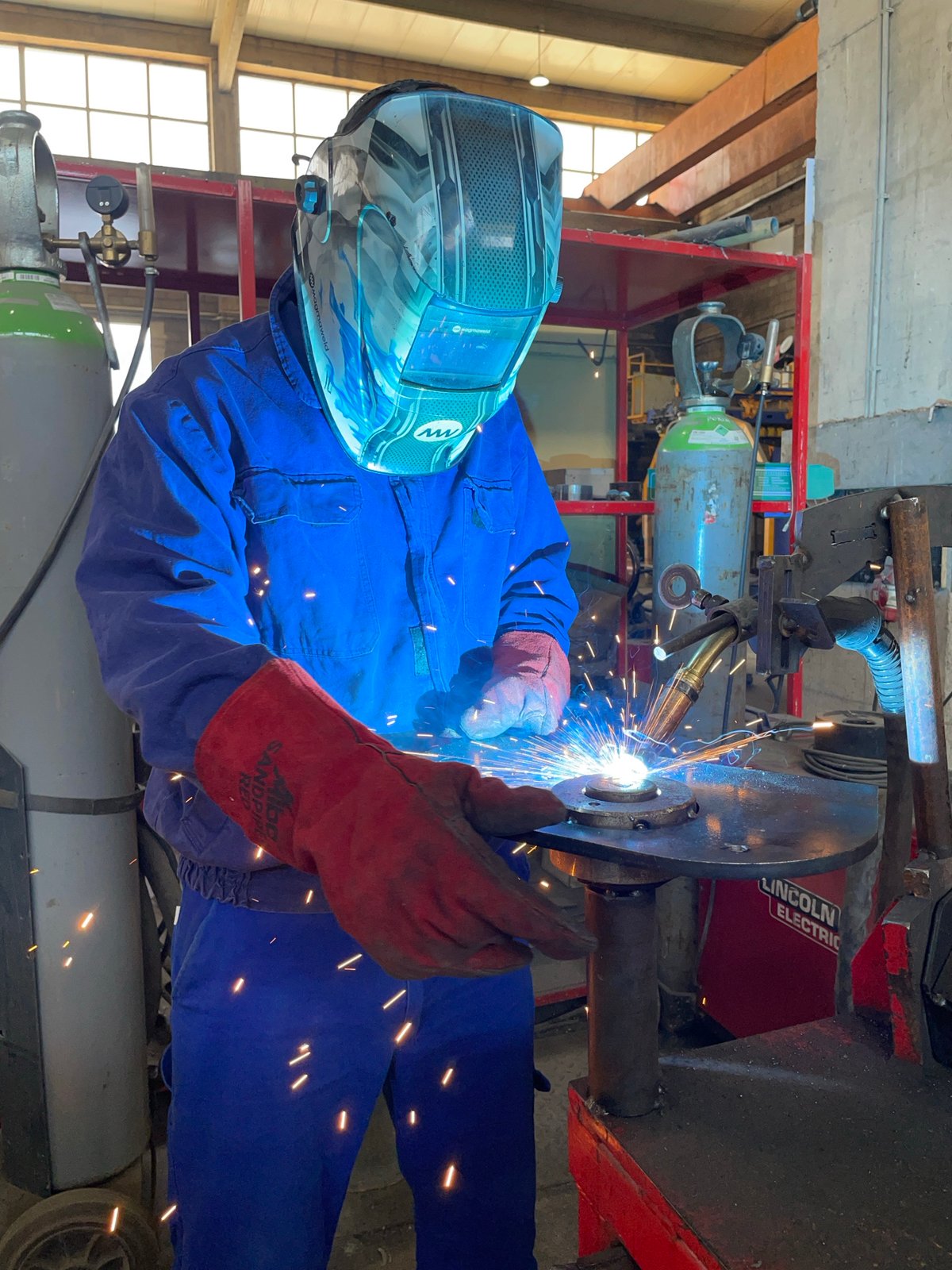 Welder at work in a Montenegrin workshop, sparks flying