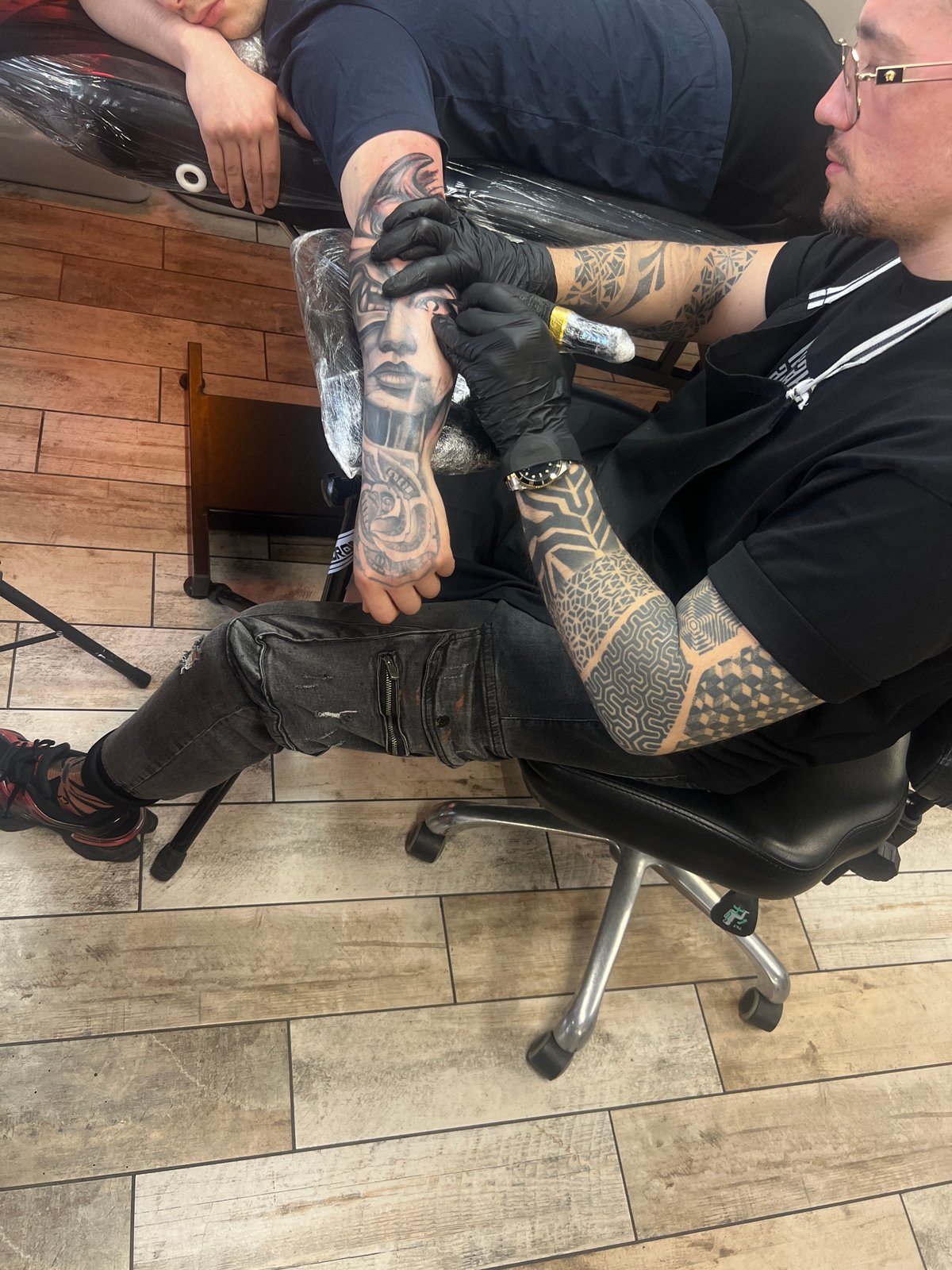 Tattoo session captured at Sofia parlor with neon decor