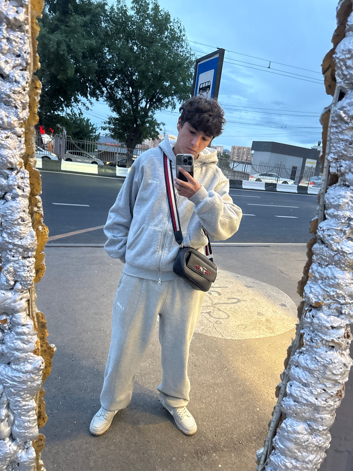 Young man takes mirror selfie at Yerevan bus stop