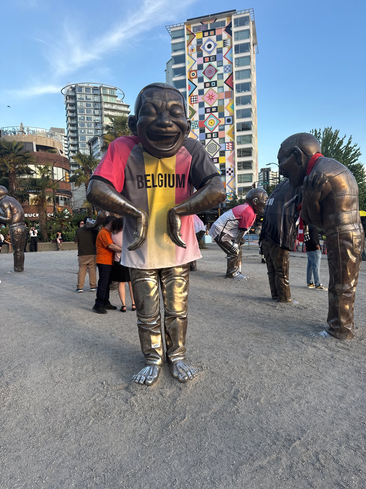 Bronze laughing figures art installation at English Bay sunset