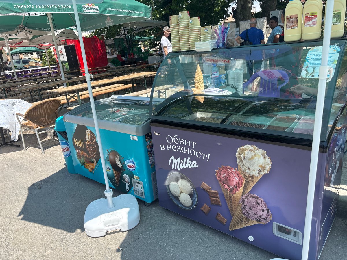 Ice cream vendors serve customers in sunny Kostievo market
