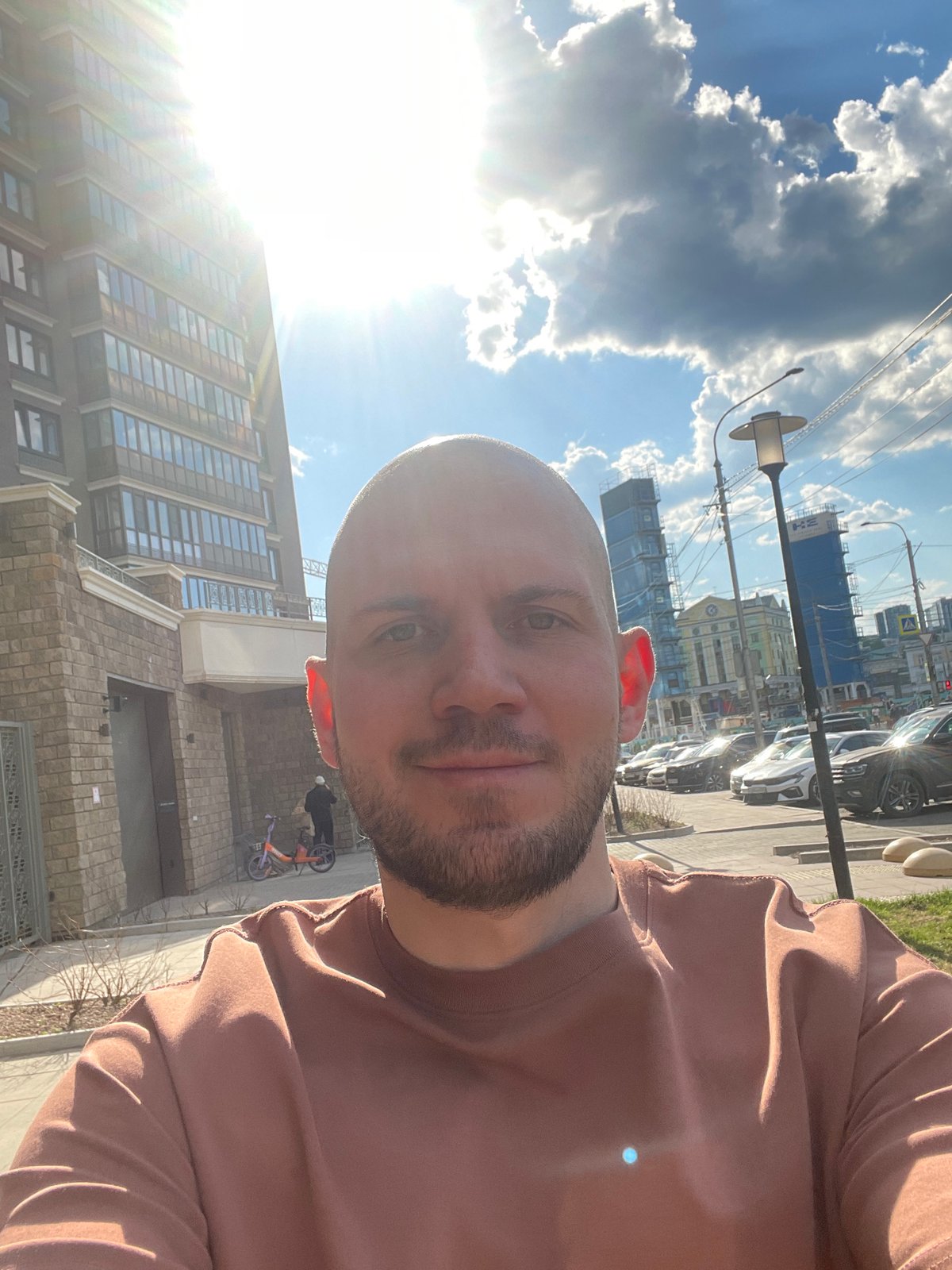 Man takes selfie on Krasnoyarsk street amid urban scene