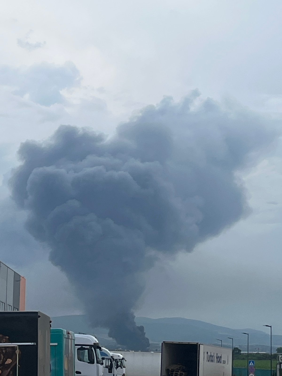 Heavy smoke plume rises over mountains from unknown fire source